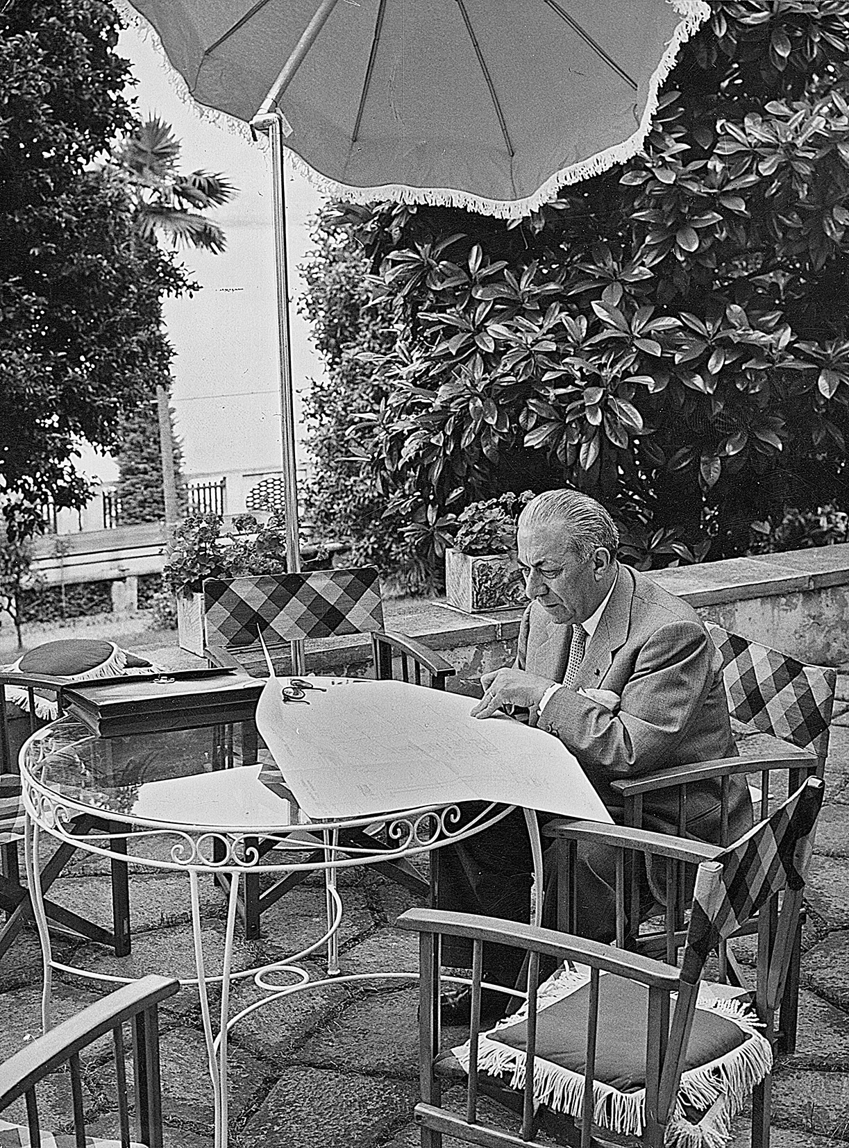 Arnoldo Mondadori legge il giornale nel giardino della sua villa a Meina, giugno 1955